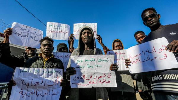 Migranten protestieren vor dem Büro des Hohen Flüchtlingskommissars der Vereinten Nationen (UNHCR) in Zarzis, Tunesien. Sie fordern den Schutz der UNO für Flüchtlinge, 25.1.2024 (IMAGO / ZUMA Press Wire / Hasan Mrad) Migranten protestieren vor dem Büro des Hohen Flüchtlingskommissars der Vereinten Nationen (UNHCR) in Zarzis, Tunesien. Sie fordern den Schutz der UNO für Flüchtlinge, 25.1.2024 (IMAGO / ZUMA Press Wire / Hasan Mrad)